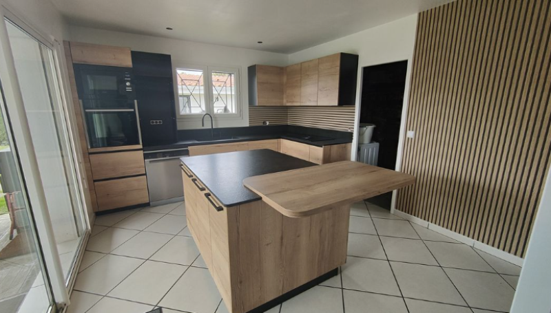 Conseils d'expert pour rénover une cuisine avec îlot central en bois naturel poignées noires et son plan de travail noir structuré à Mérignac près de Le Haillan